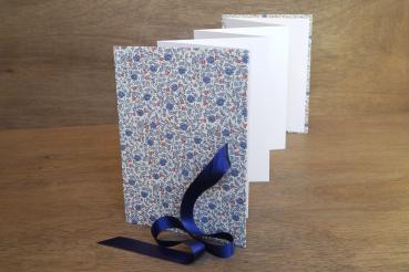Leporello open, accordion, light photo cardboard, cover with decorative paper and blue flowers, blue satin bow
